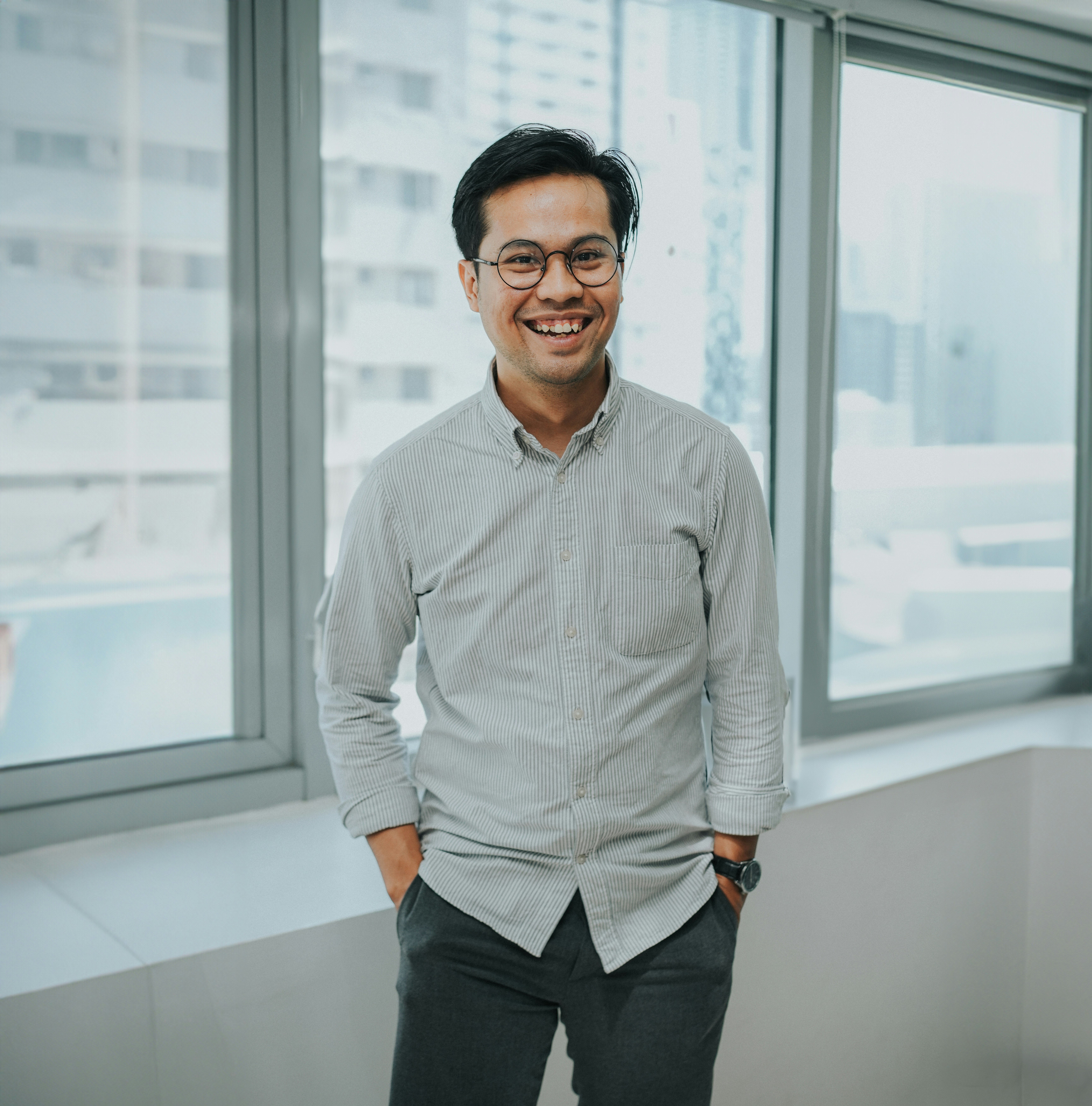 A man standing in front of a window smiling