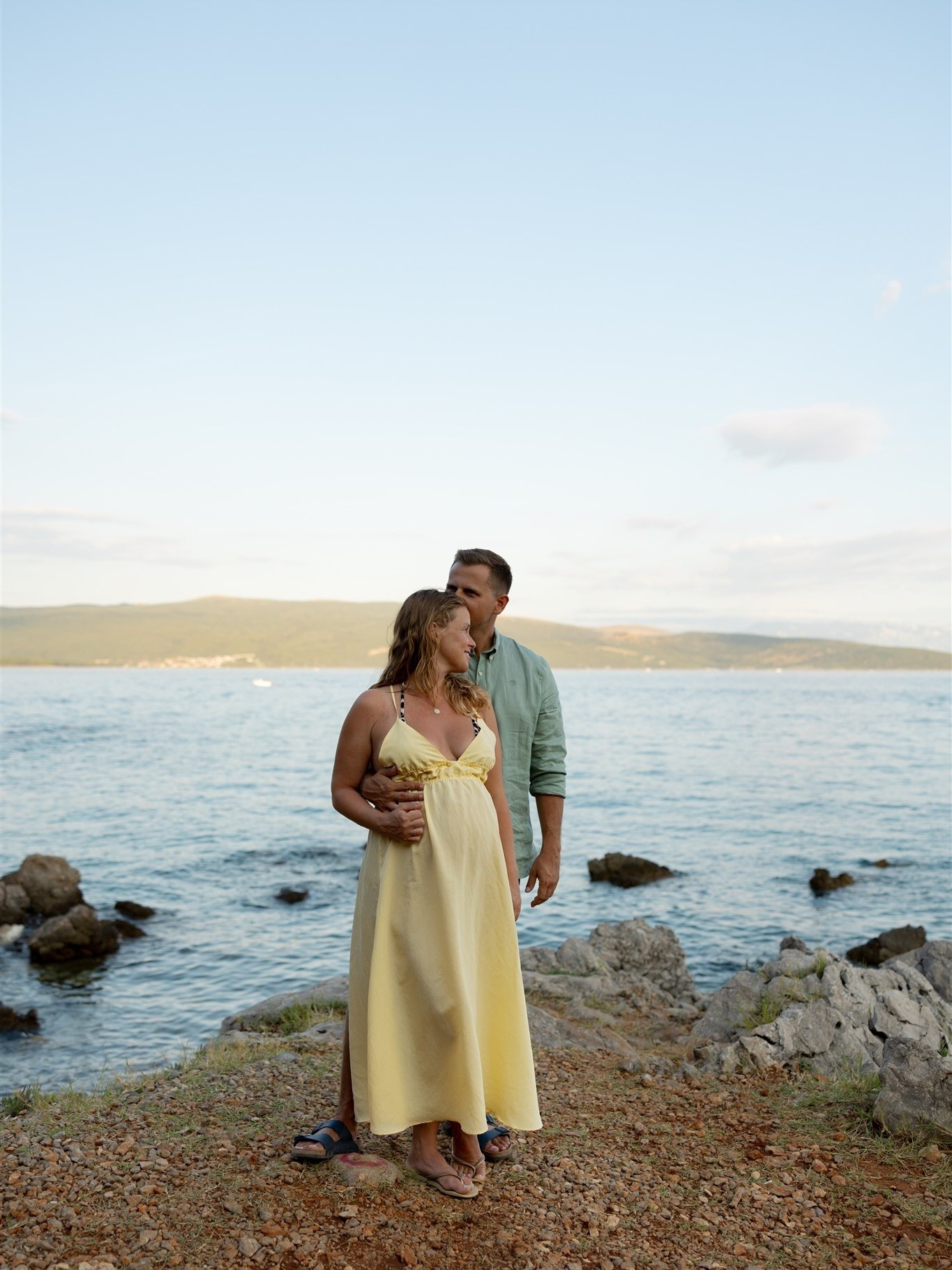 Portrait of a couple posing in the late summer sun next to sea
