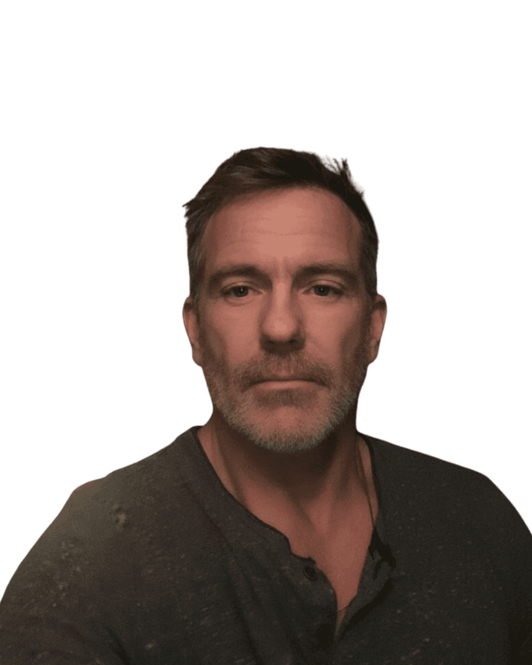 Smiling female therapist with short gray hair, wearing a brown top and a purple shawl, surrounded by a cozy background.