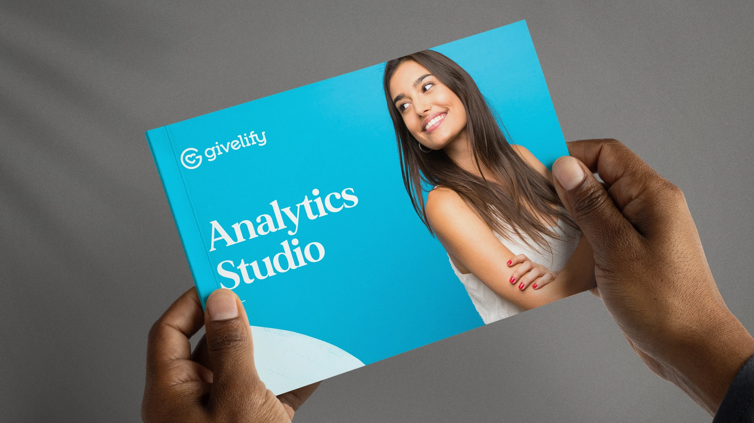 Hands holding a guidebook on Givelify's advanced new Analytics Studio feature