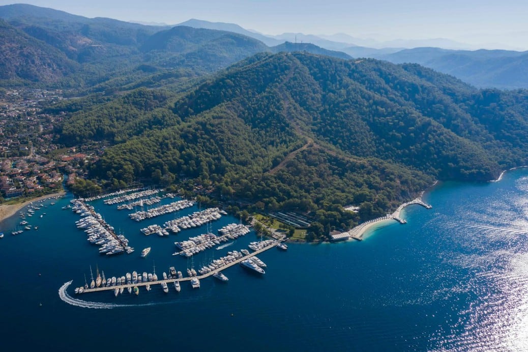 Aerial view of a yacht marina on the Turkish Mediterranean coast, showing berths, coastal facilities and surrounding landscape.
