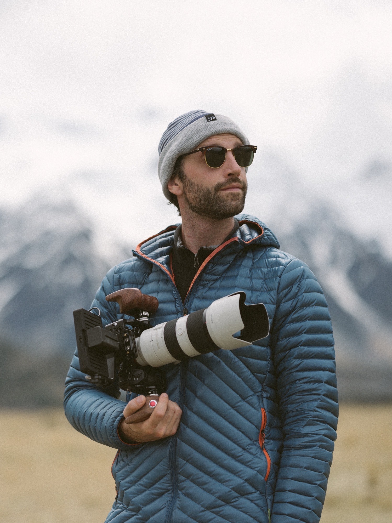 Jamie Plunkett, Apertunity co-founder, holding a cinema camera with a long telephoto lens