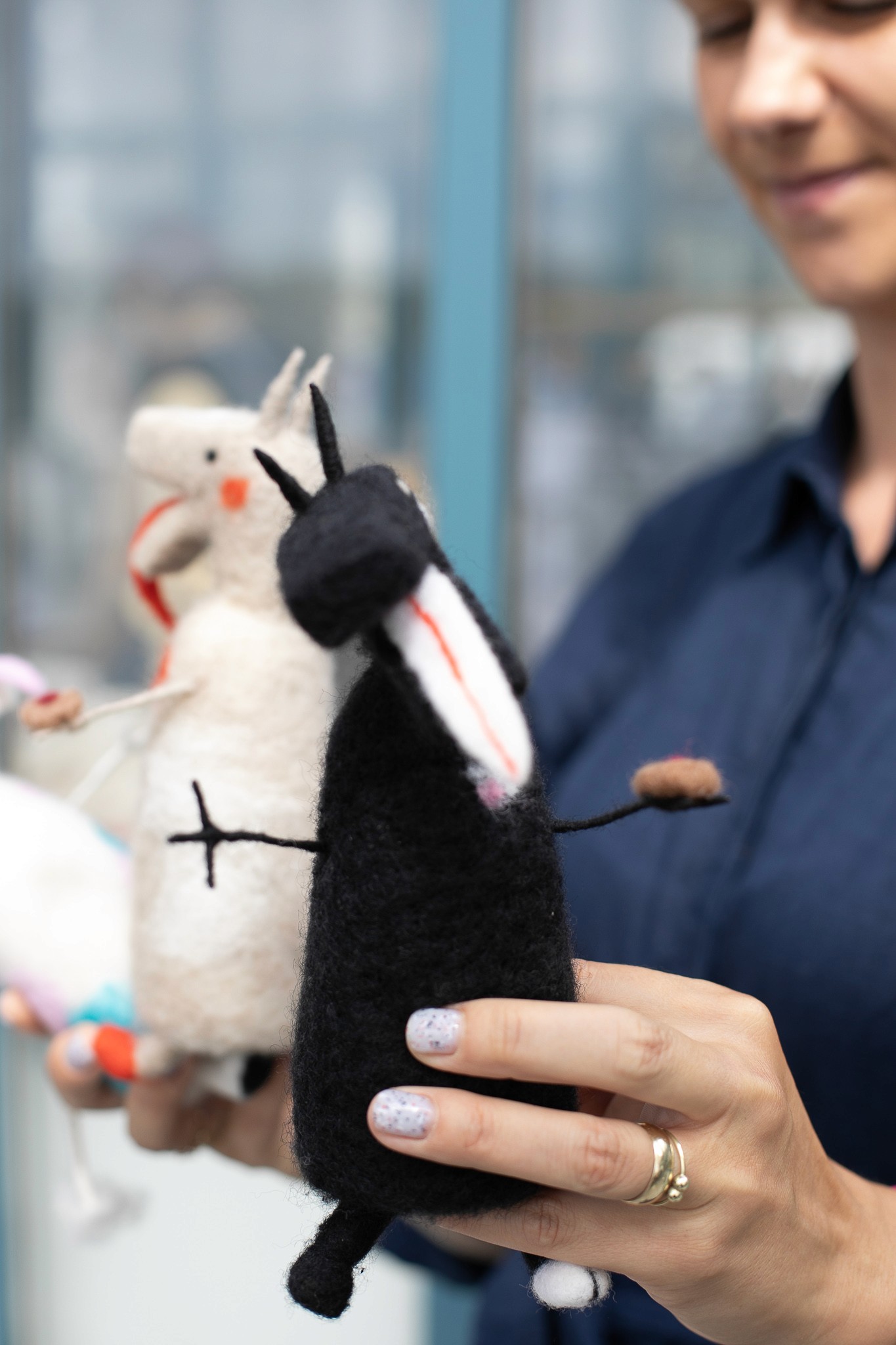 Záber na čierneho turoňa z vlny s bielymi detailmi, držaného v ruke.