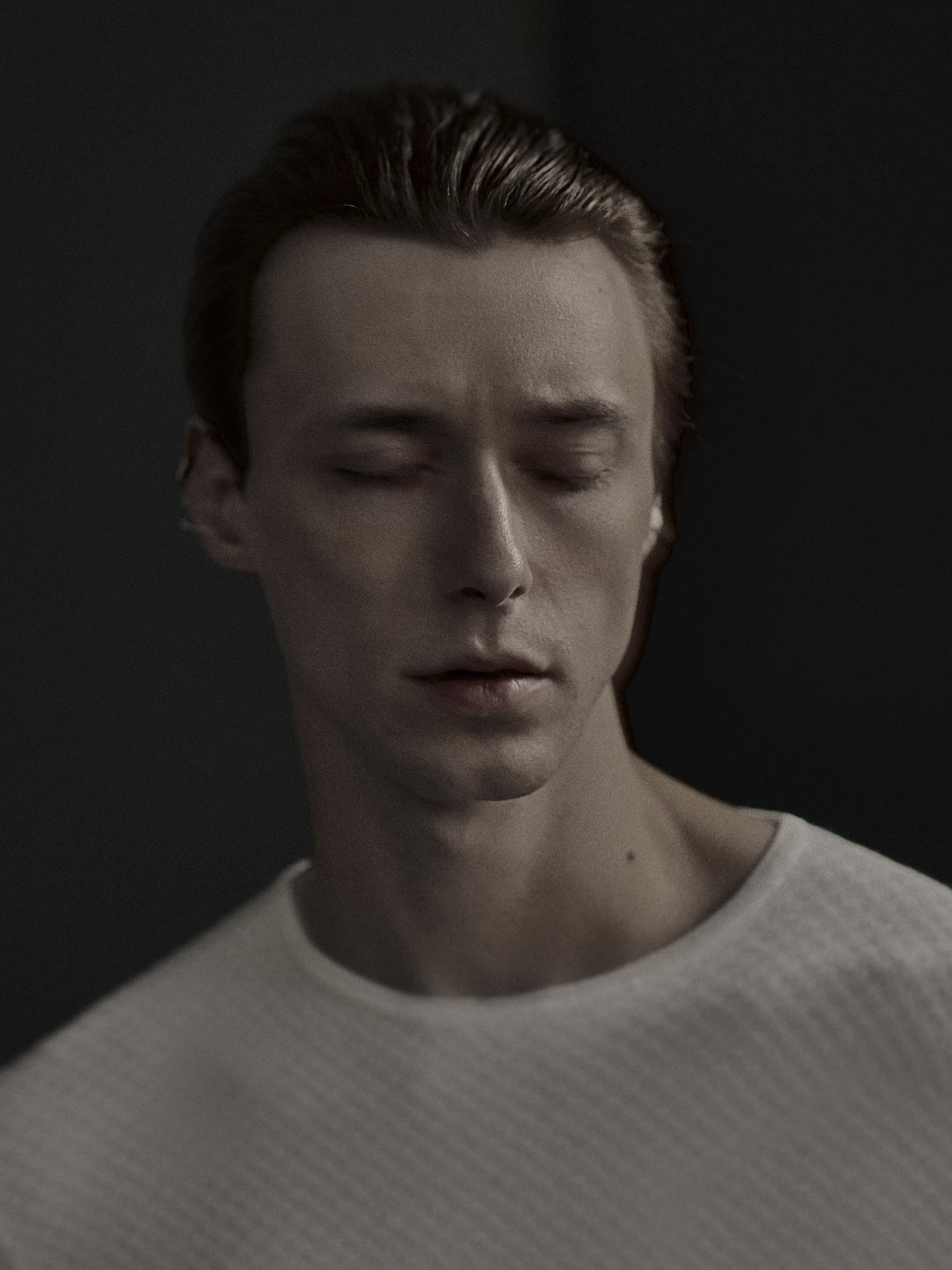 A moody and expressive photographic portrait of a young man. 