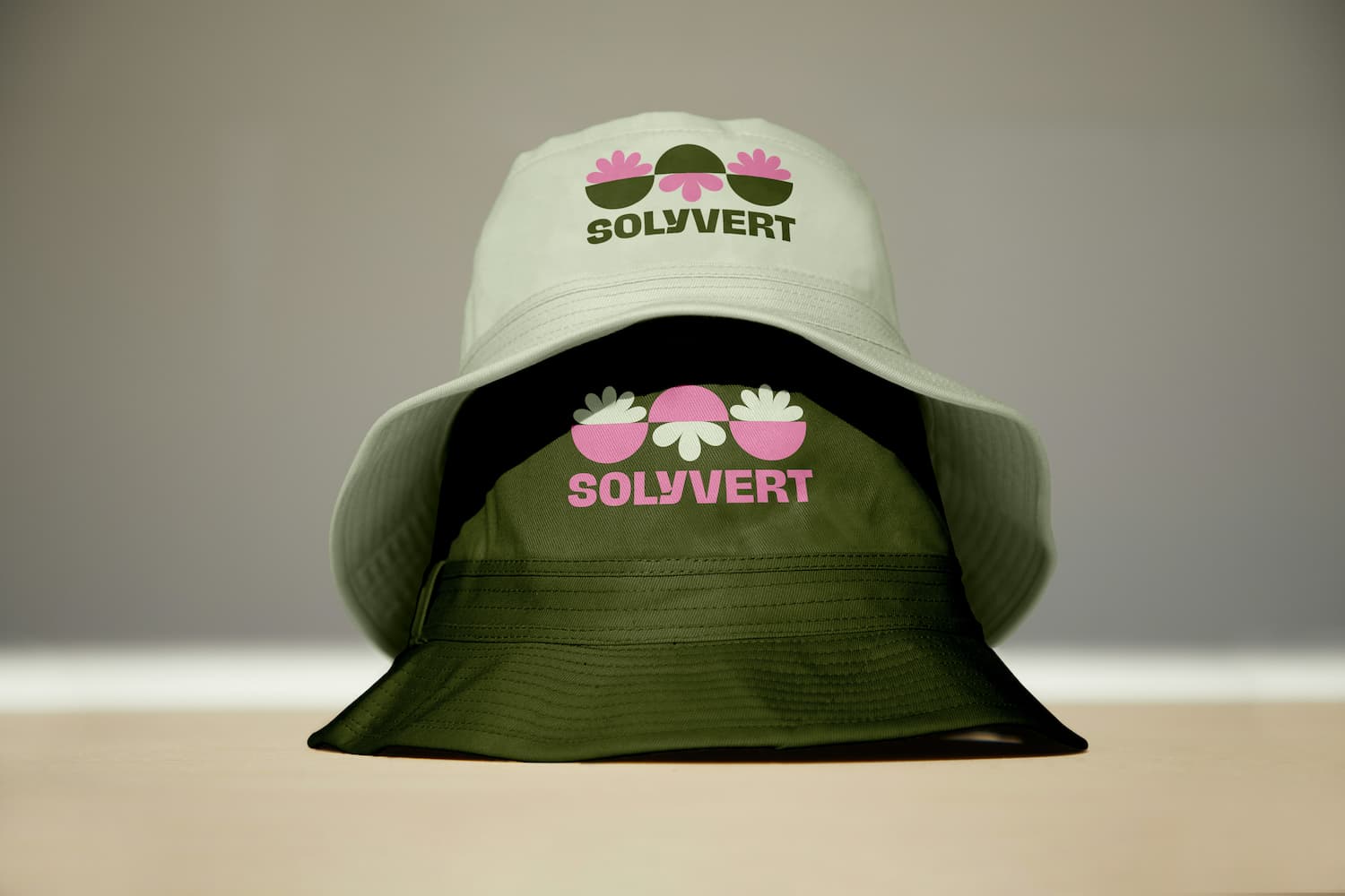Two bucket hats in green and white featuring the Solyvert primary logo on the front.