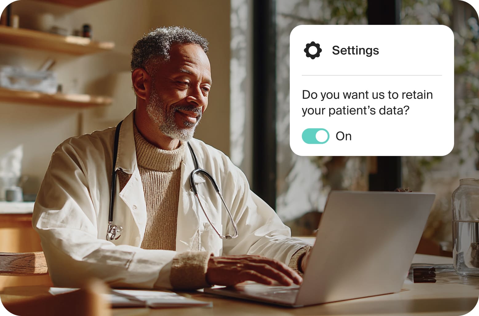 A smiling male doctor typing on his laptop.