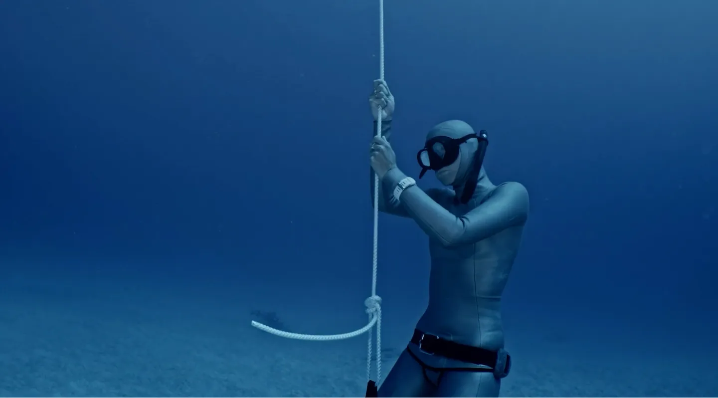 Underwater Freediver holding a rope