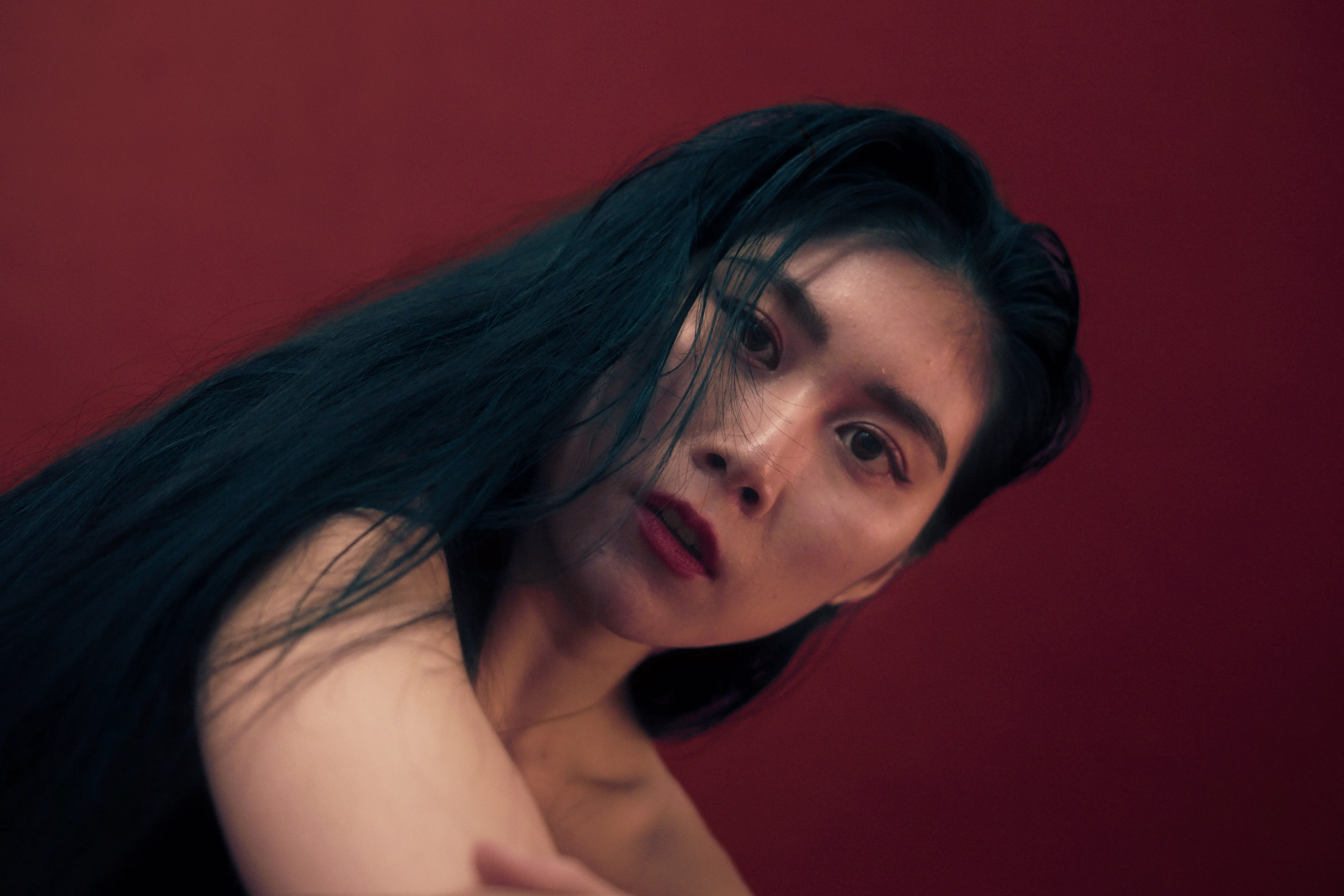 Editorial Portrait Frau Studio Frankfurt geneigter Blick Close Aufnahme roter Hintergrund