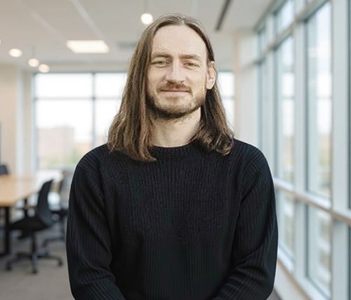 woman staring directly at camera near pink wall