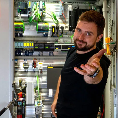 Žmogus rodo ranka į jus prie elektros skydinės