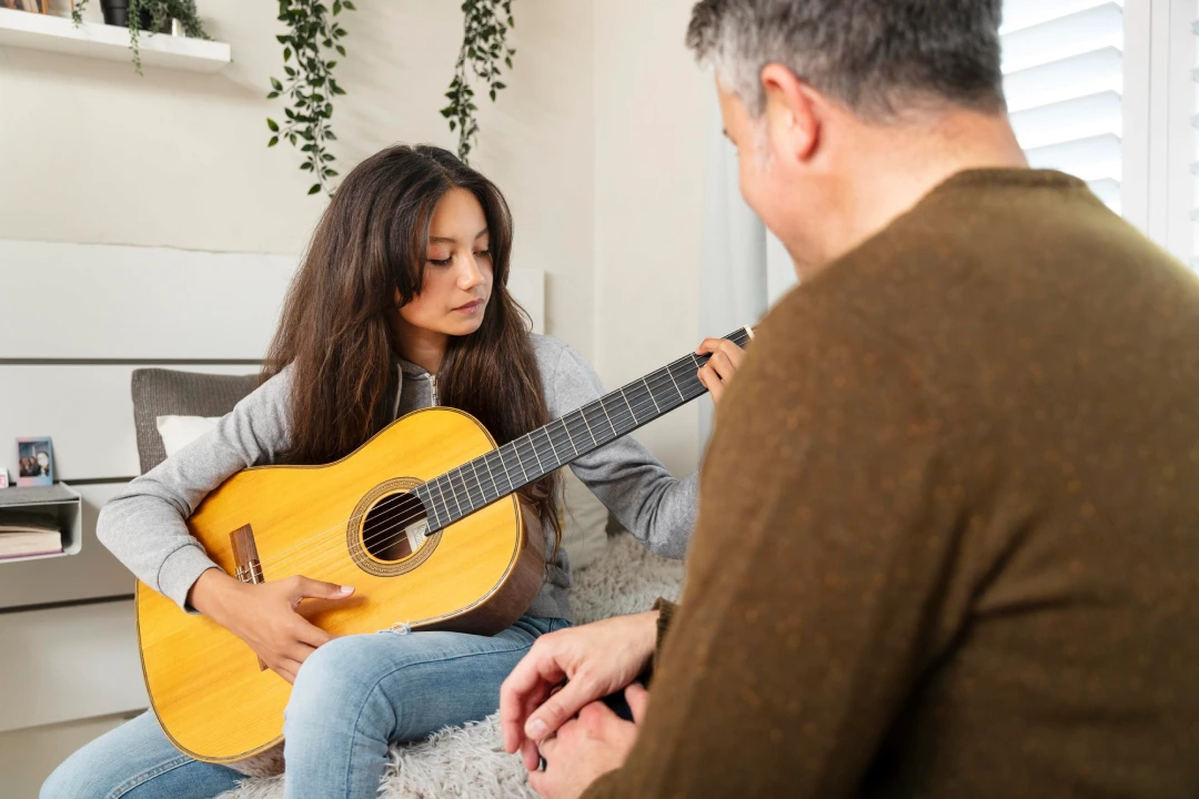 Young woman playing guitar, highlighting music therapy benefits for managing stress and staying sober.