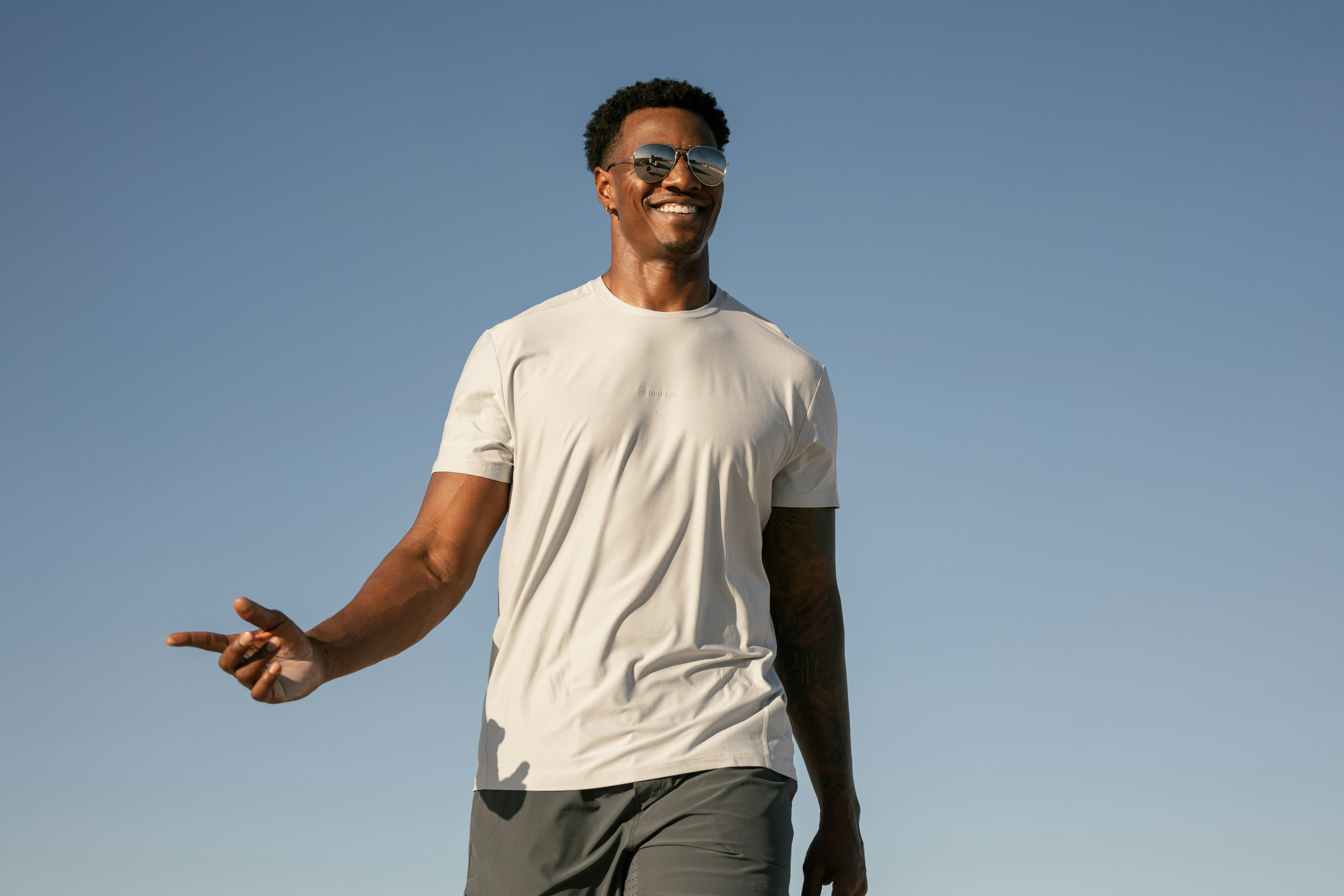 Man smiling in a sports outfit in a sunny environment.