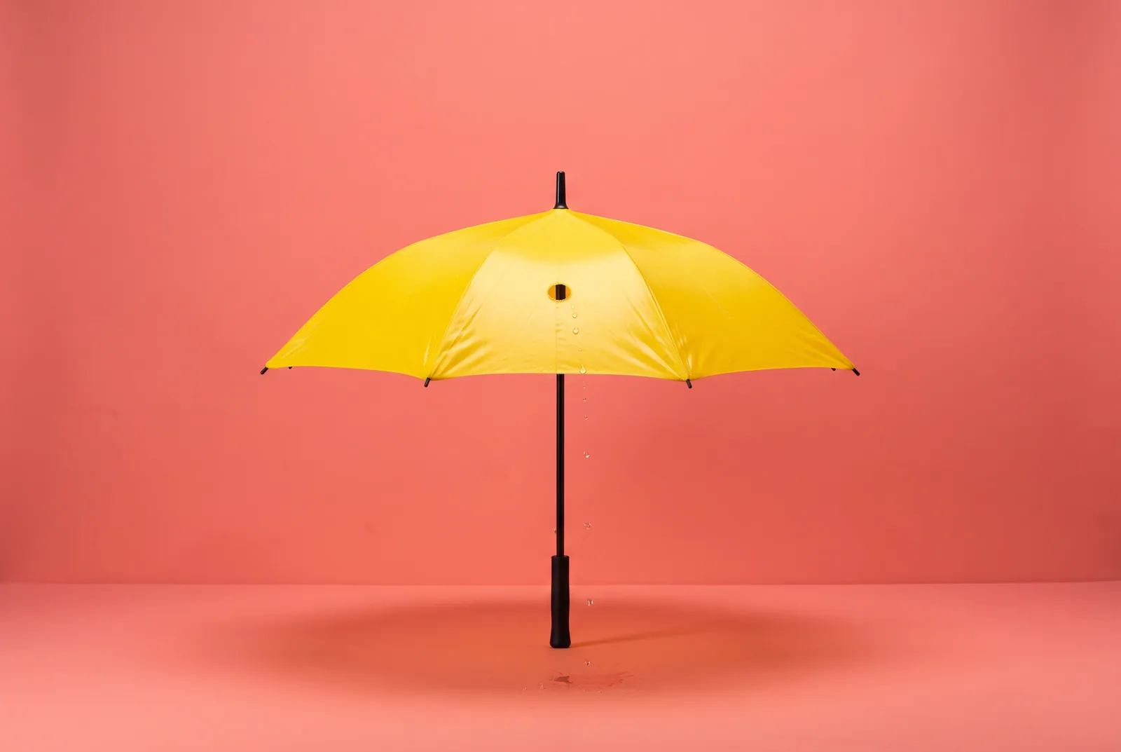 A yellow umbrella with one small hole letting a few raindrops through, a symbol of the limits of parental controls to block porn