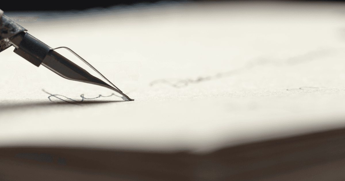 Tall grasses or reeds silhouetted against a hazy, golden sunrise or sunset.