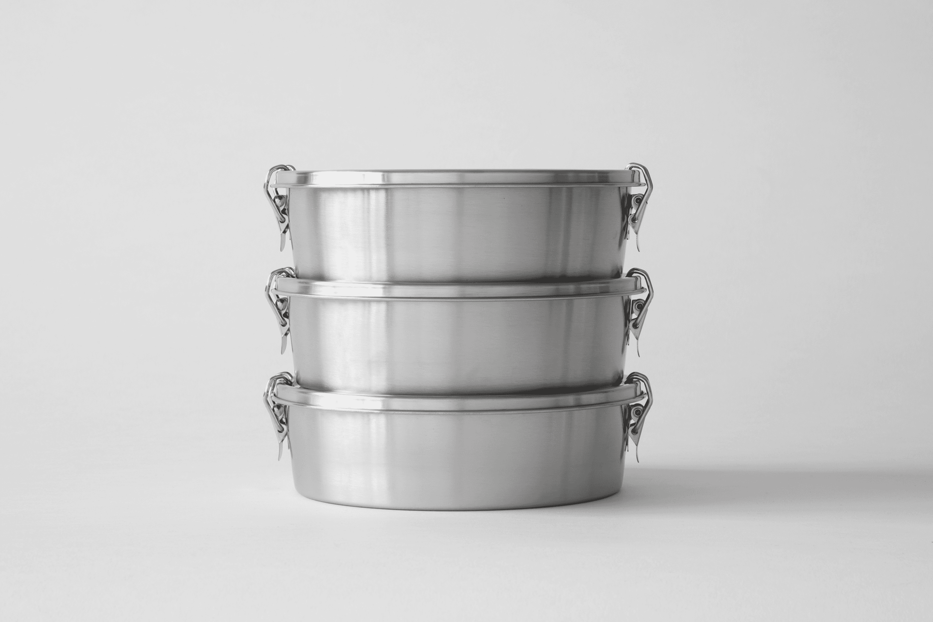 Three stacked stainless steel lunch containers.