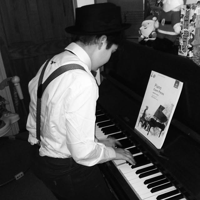 Black-and-white photograph of Isaiah practicing piano