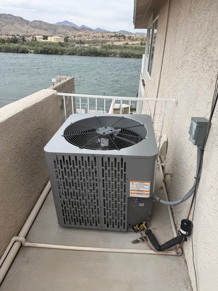 Air Time technician cleaning an outdoor AC unit during routine maintenance in Mohave Valley, AZ