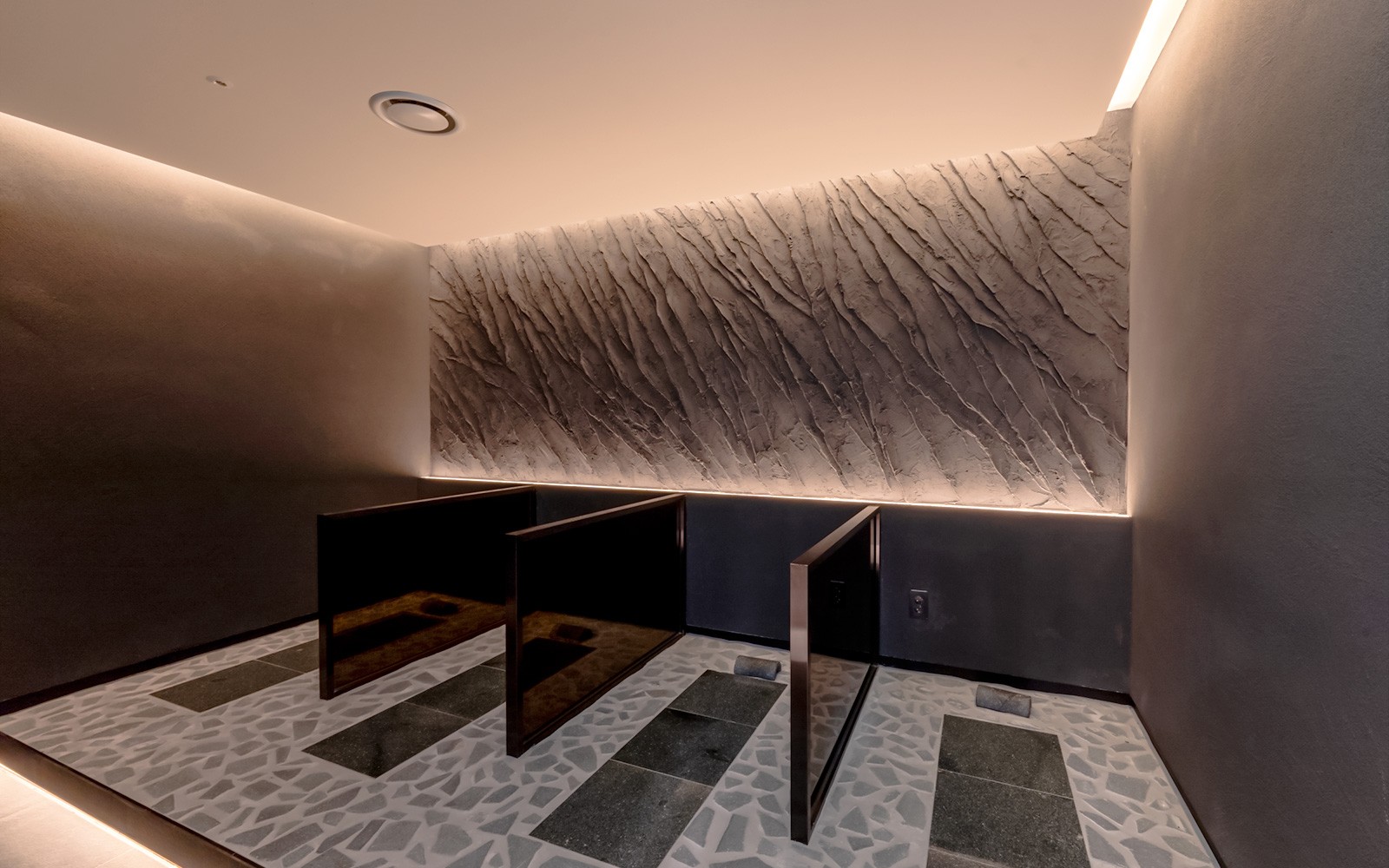 Частные душевые кабины в спа-салоне Club D Oasis с текстурированными стенами.