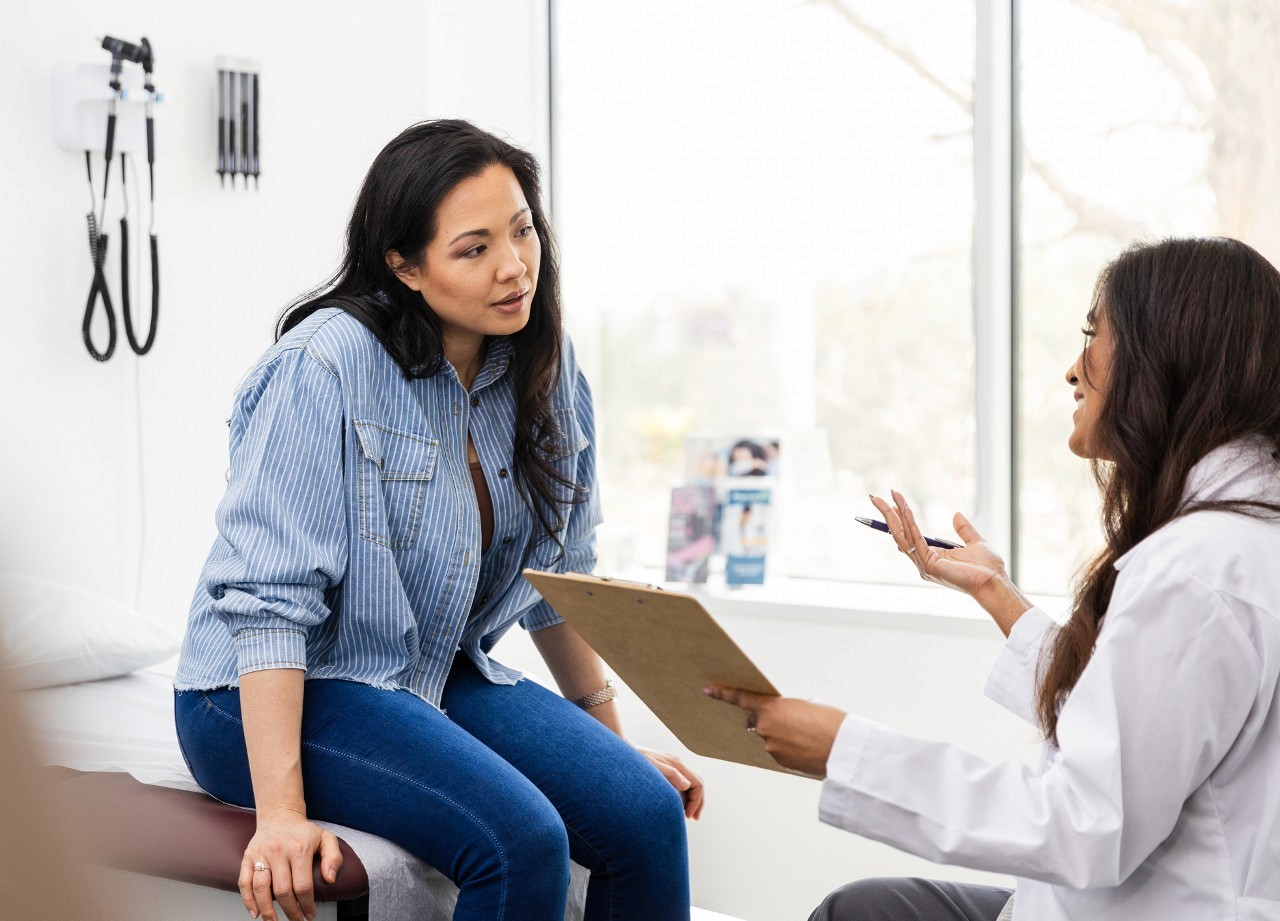 Woman discussing STI screening and treatment with a doctor.