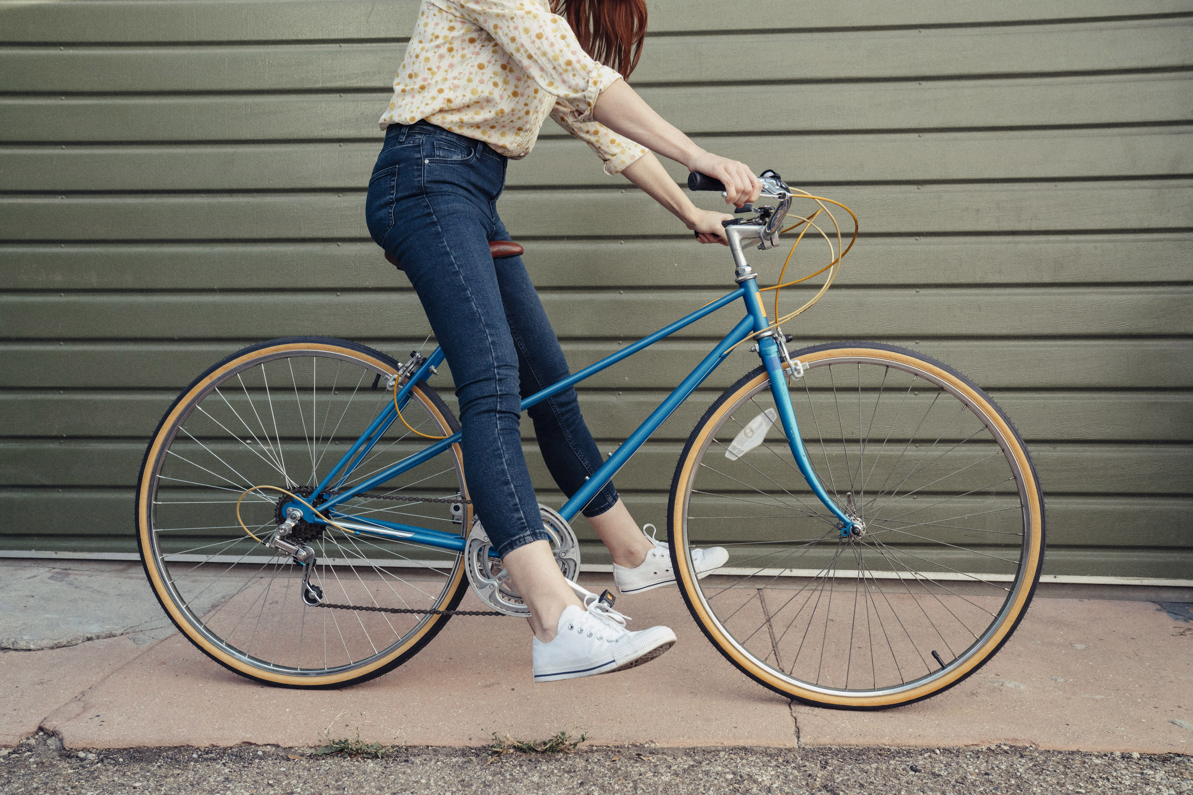 A woman riding a blue bicycle