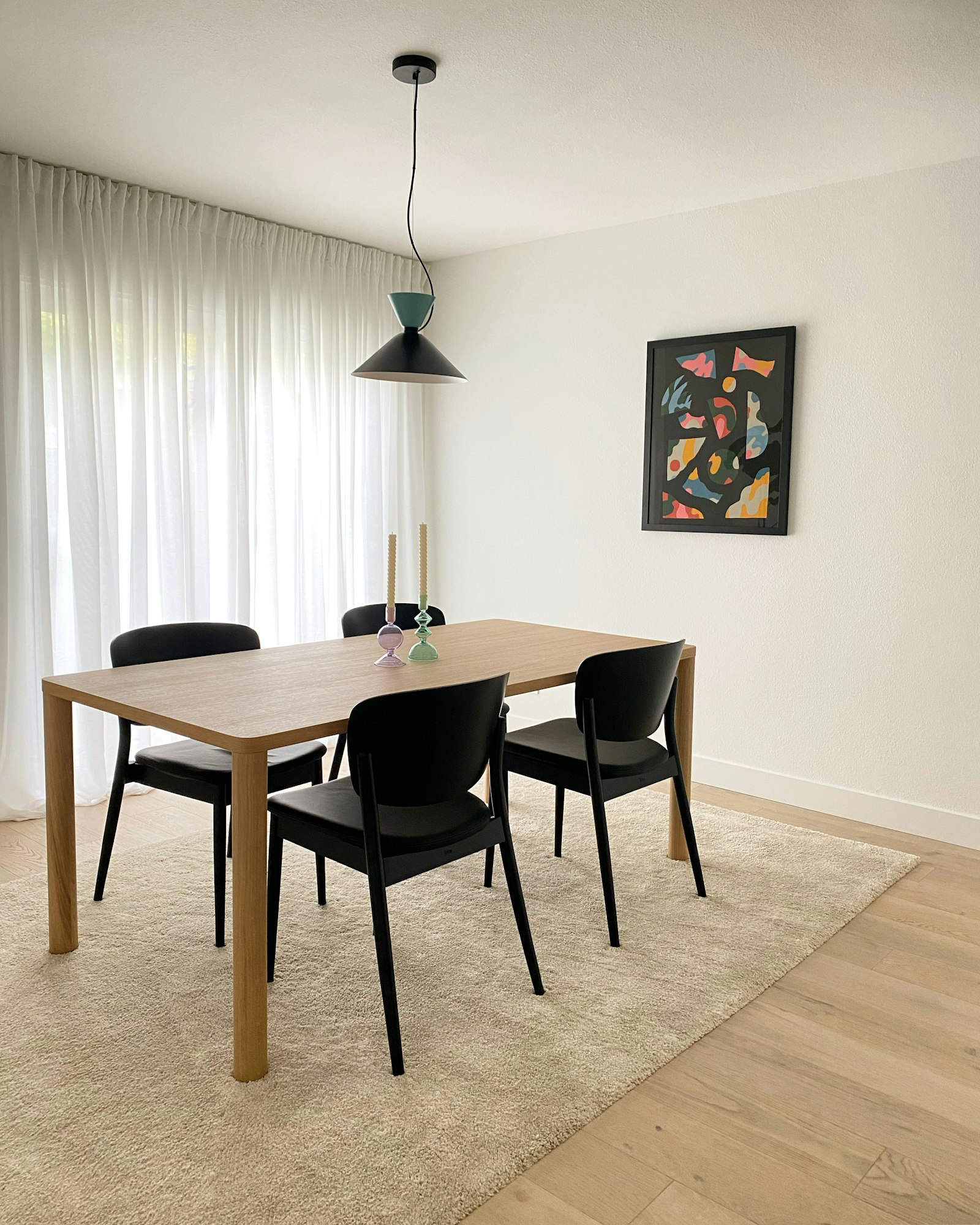 A dining table set with a vase of flowers