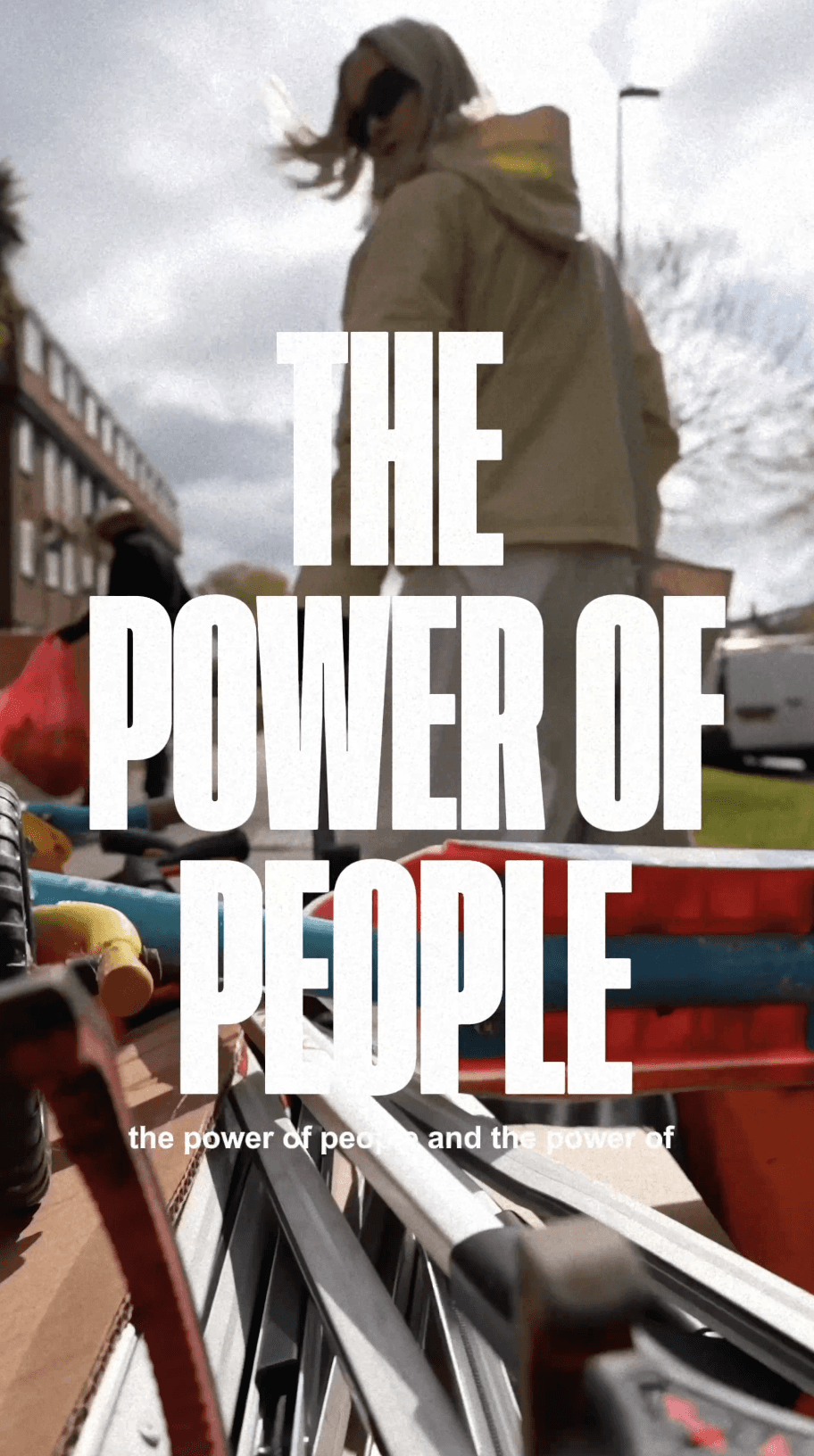 Bride sitting on ground against wall, groom standing nearby