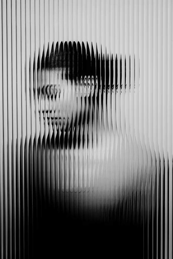 A vague female bust is behind the glass.