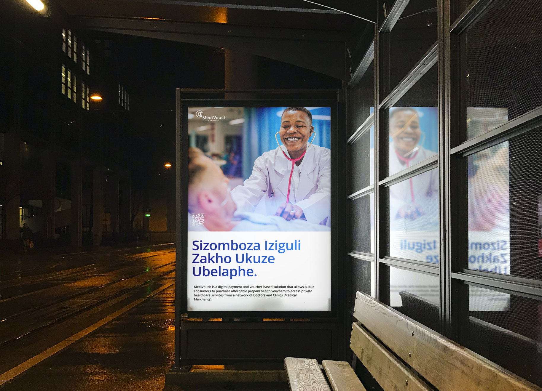 A MediVouch poster illuminates the bus stop at night