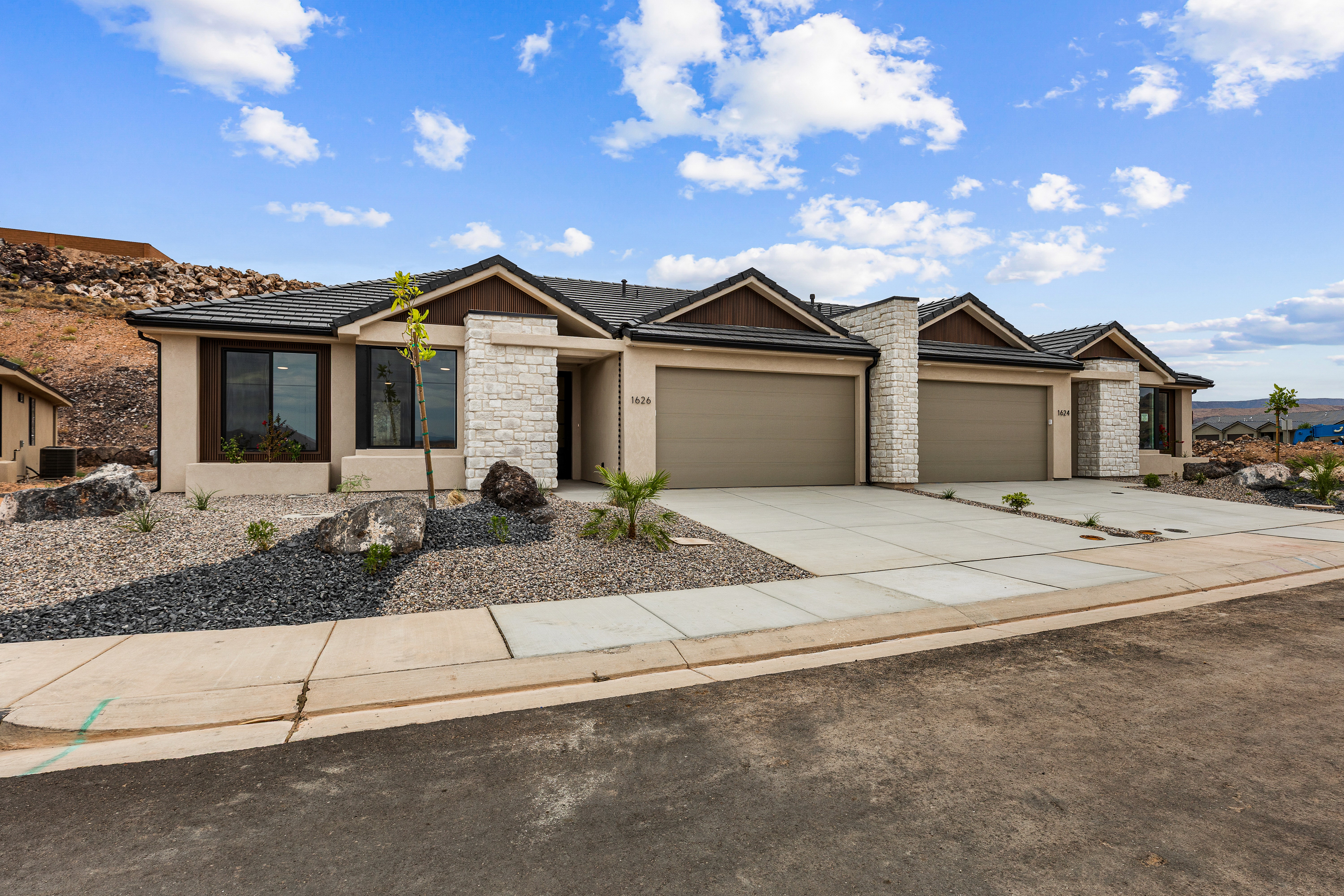 Custom home exterior with stone accents and desert rock landscaping on a cul-de-sac in Hurricane, Utah.