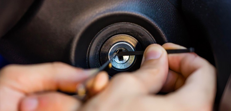 locksmith using pick tool to turn car ignition to on position