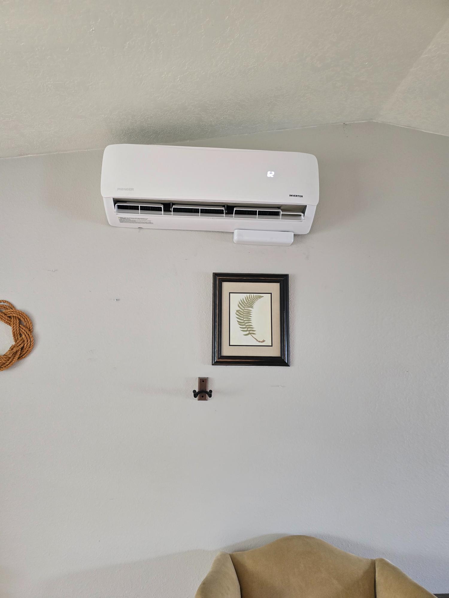White ductless mini split unit installed on a living room wall.