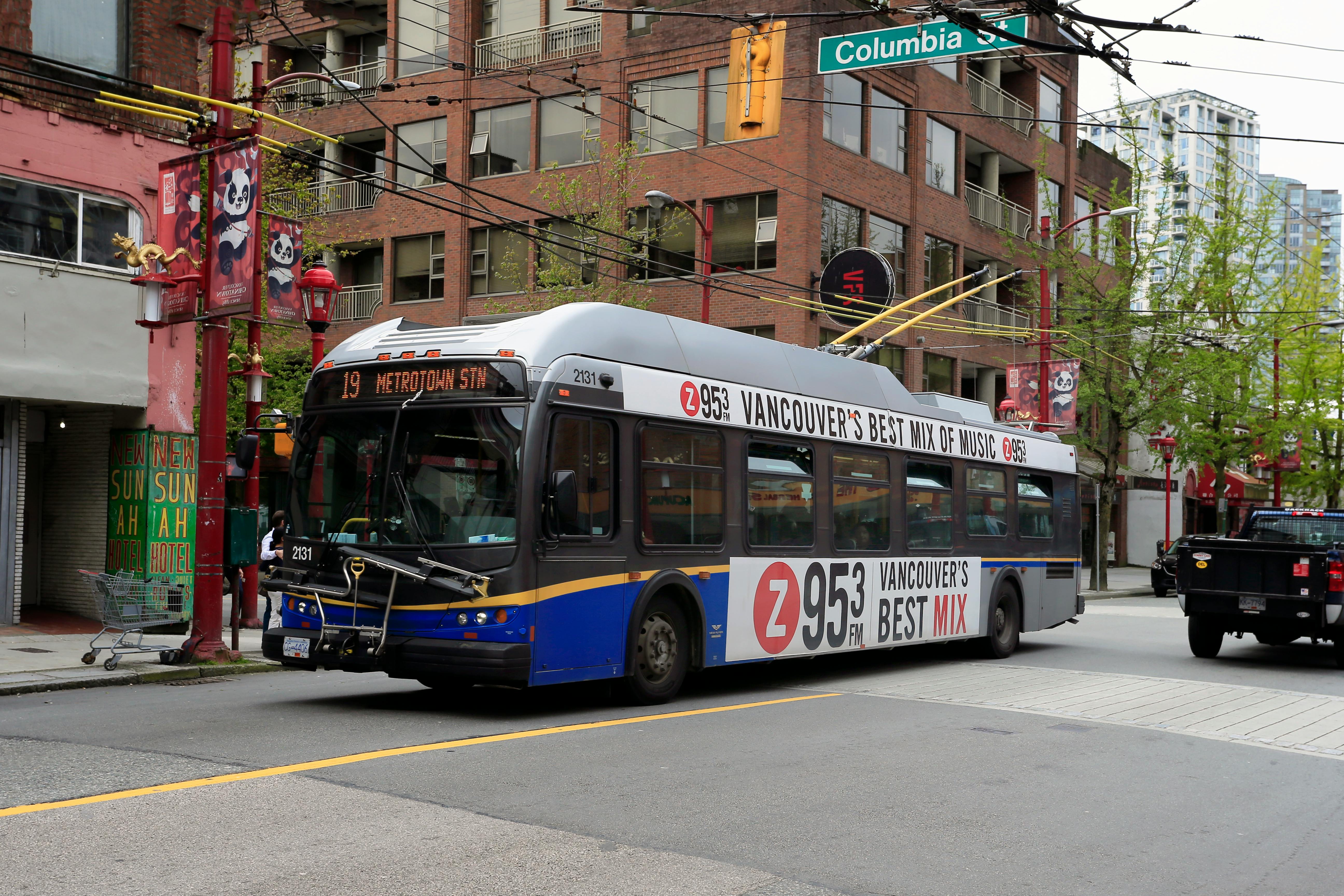 TransLink trolleybus running the 19 Metrotown Station route past Columbia Street in Vancouver Chinatown, highlighting affordable public transit options for newcomers.
