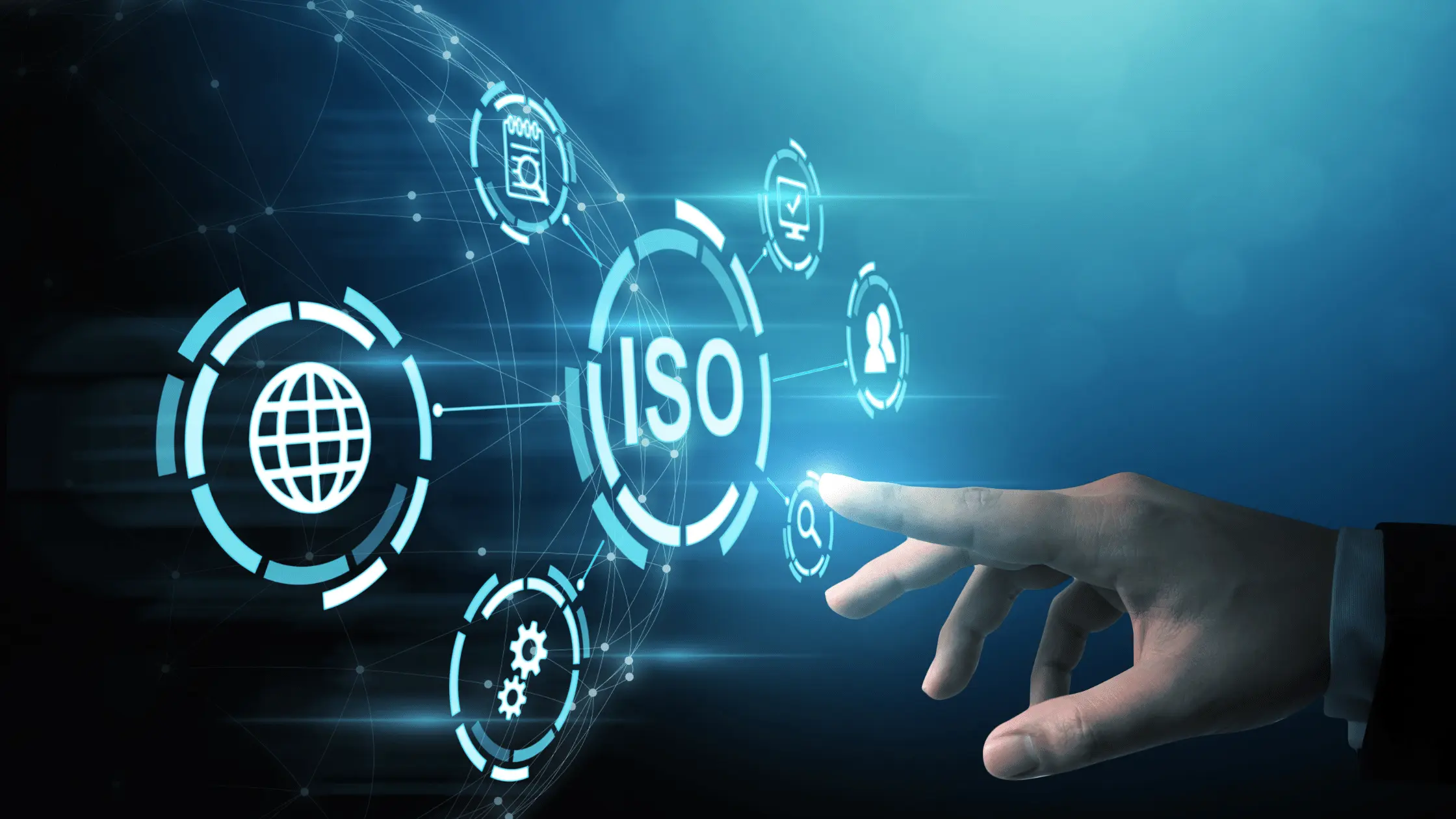 A man stands while two people sit at a table in an office setting, smiling and engaged in conversation. The mood is friendly and collaborative.