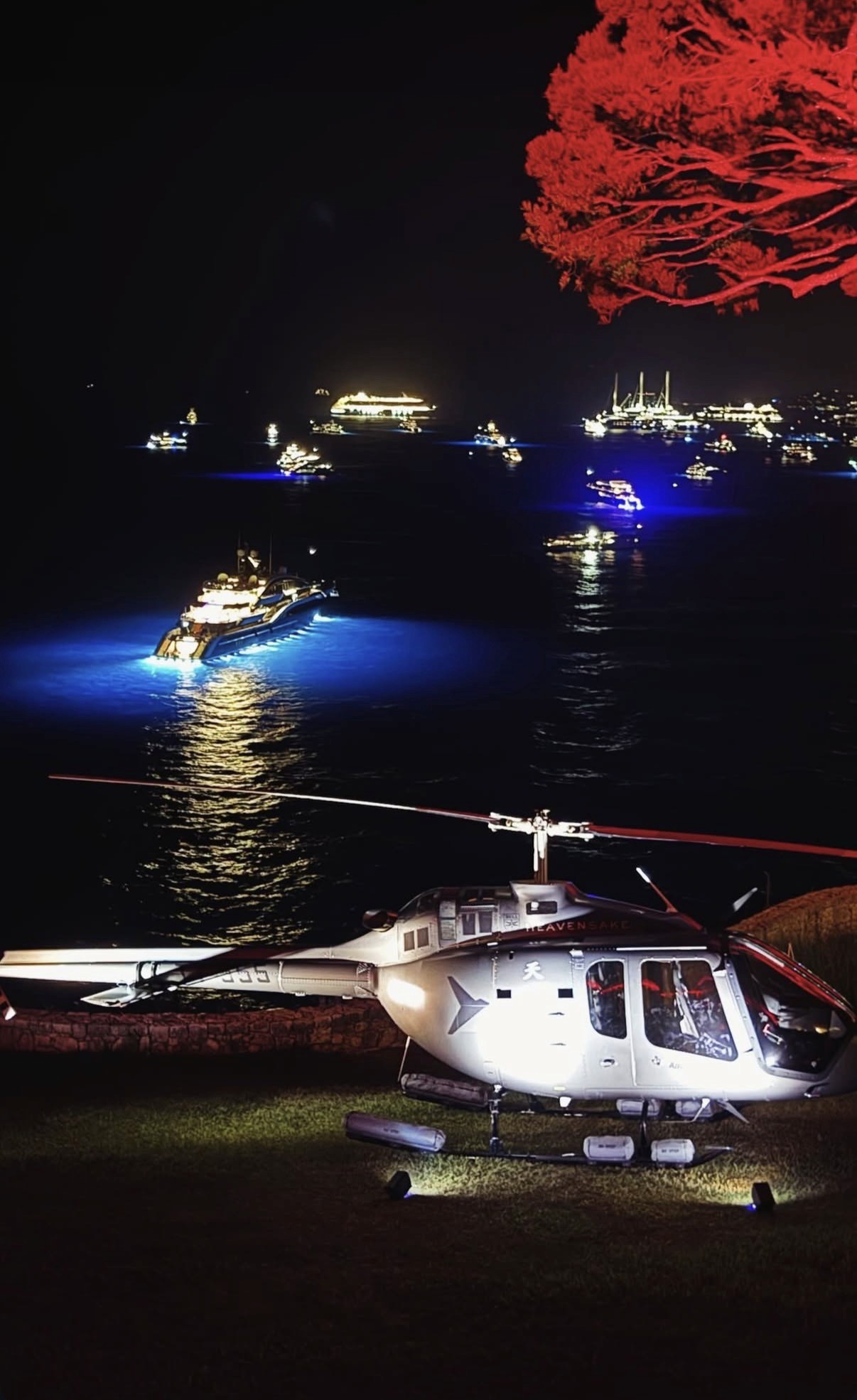 Hélicoptère et yachts illuminés lors d’une soirée privée face à la mer