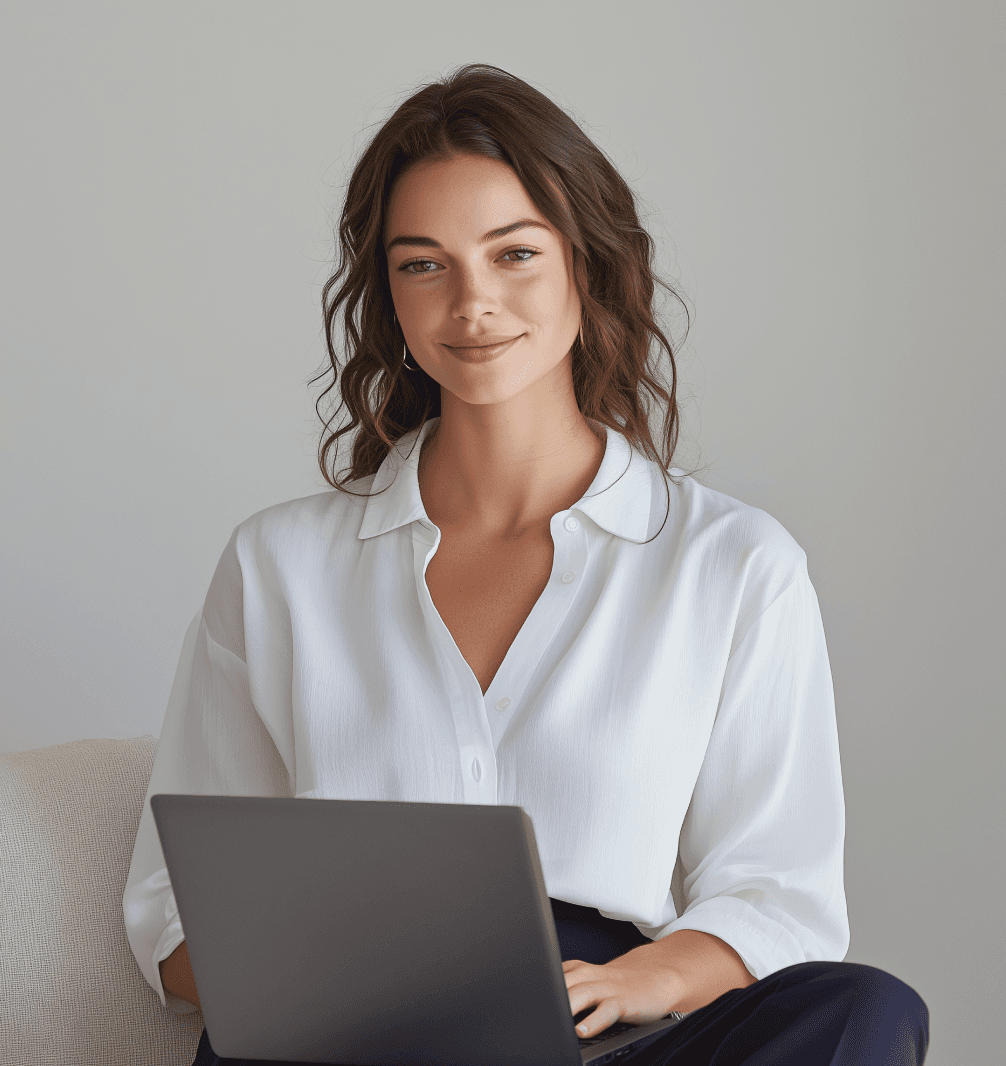 Female professional seated and working on laptop against neutral background