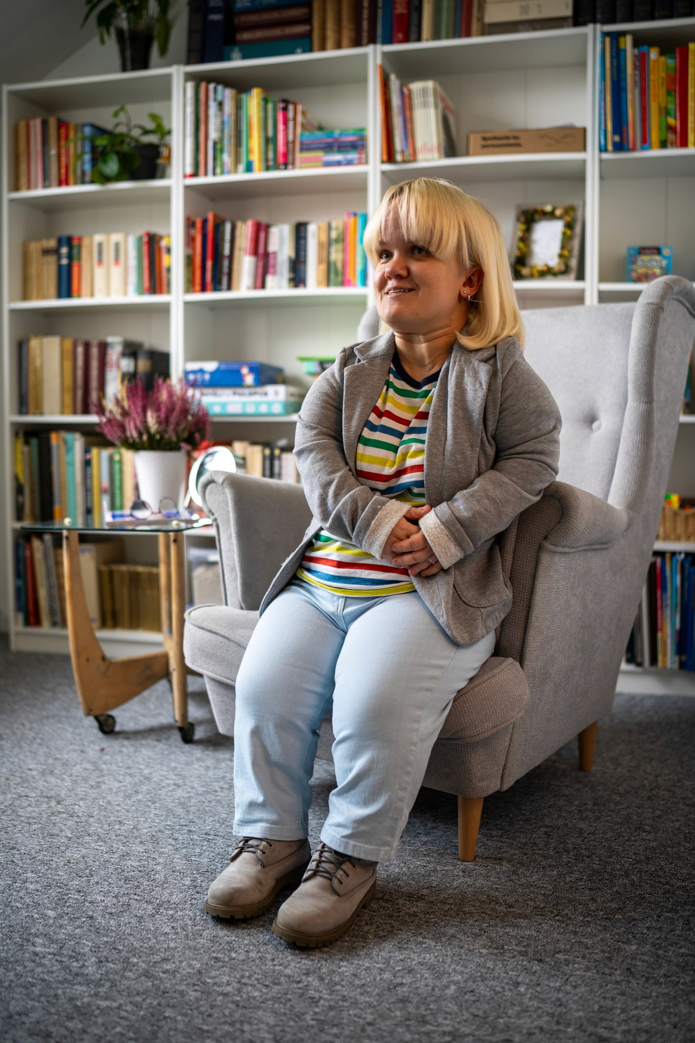 Portret psychoterapeutki Magdaleny Krzysztoń na tle regału z książkami