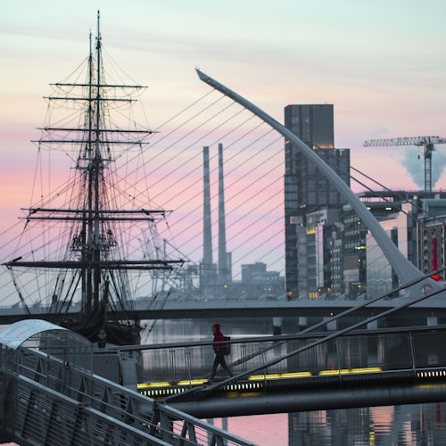 Dublin's River Liffey with a view of the Seab O'Casey bridge in the foreground, with the Jeanie Johnston ship behind it