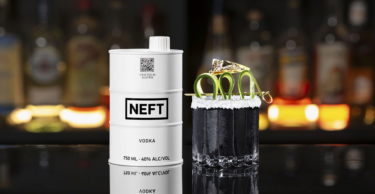 A NEFT Barrel and a glass of Black Gold on a bar counter.