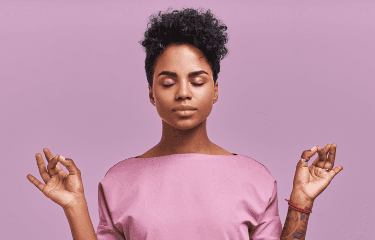 A woman in a pink outfit with eyes closed in a peaceful, meditative pose against a purple background, representing stress relief and mindfulness
