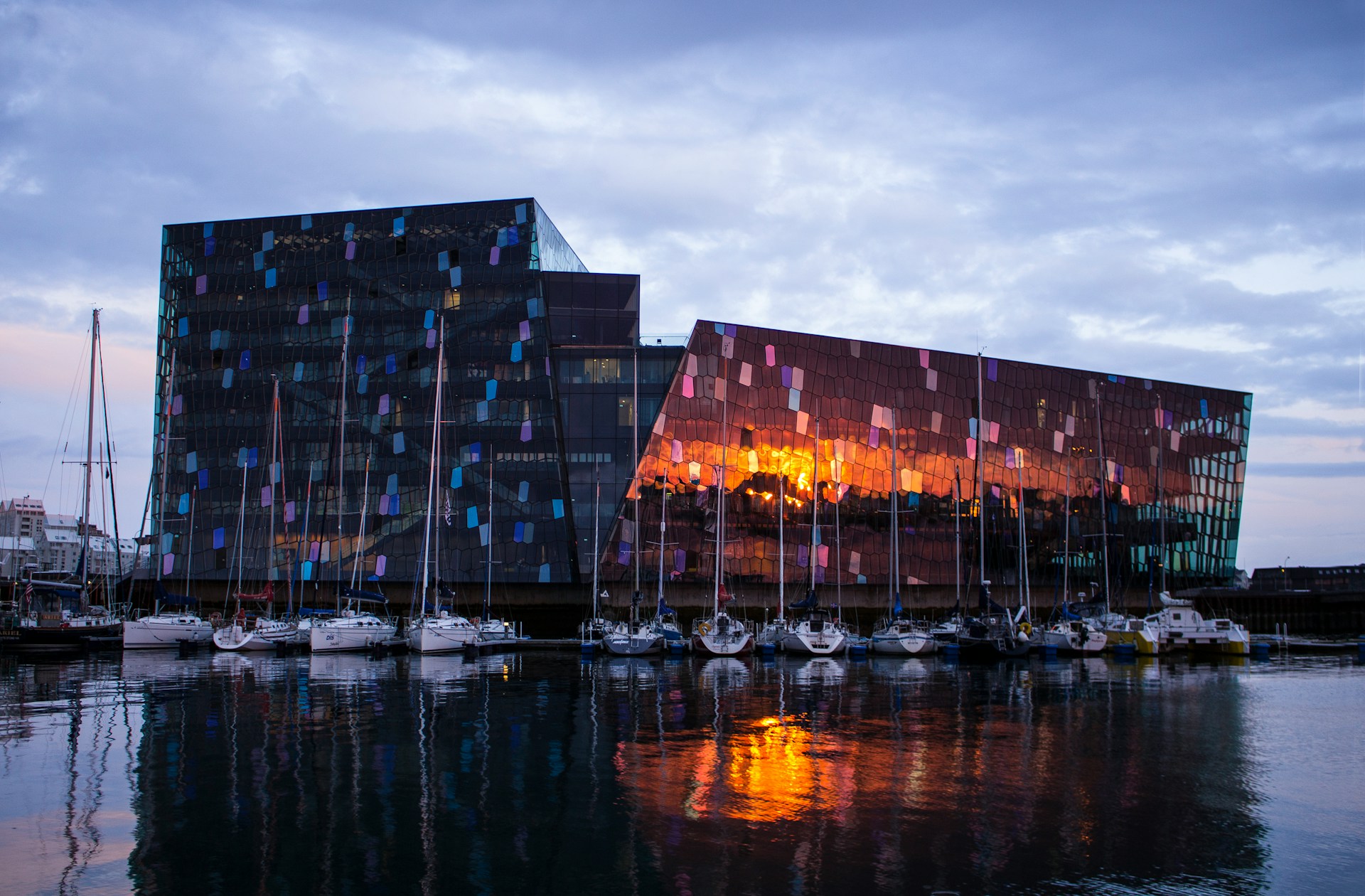 Harpa Concert Hall in Reykjavik, Iceland, overlooking boats in the harbor.