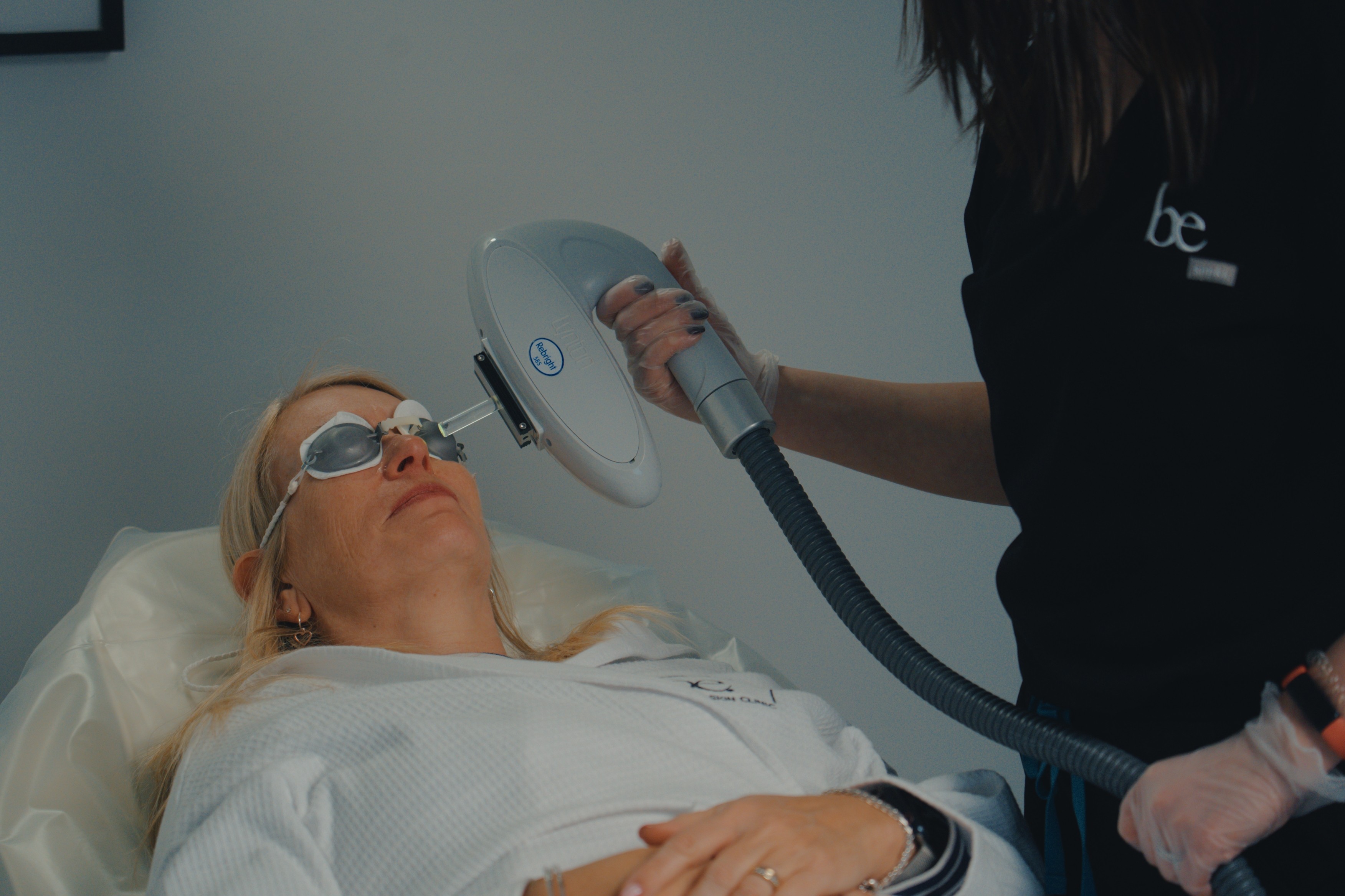 Woman receiving laser treatment on face.