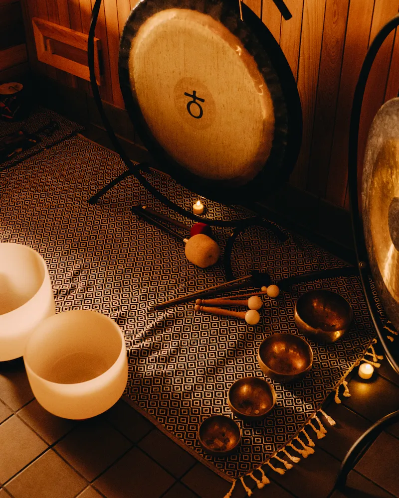 Ceremonial instruments such as sound bowls and a gong used during guided sauna rituals, supporting rhythm, focus, and sensory coordination in Aufguss sessions.