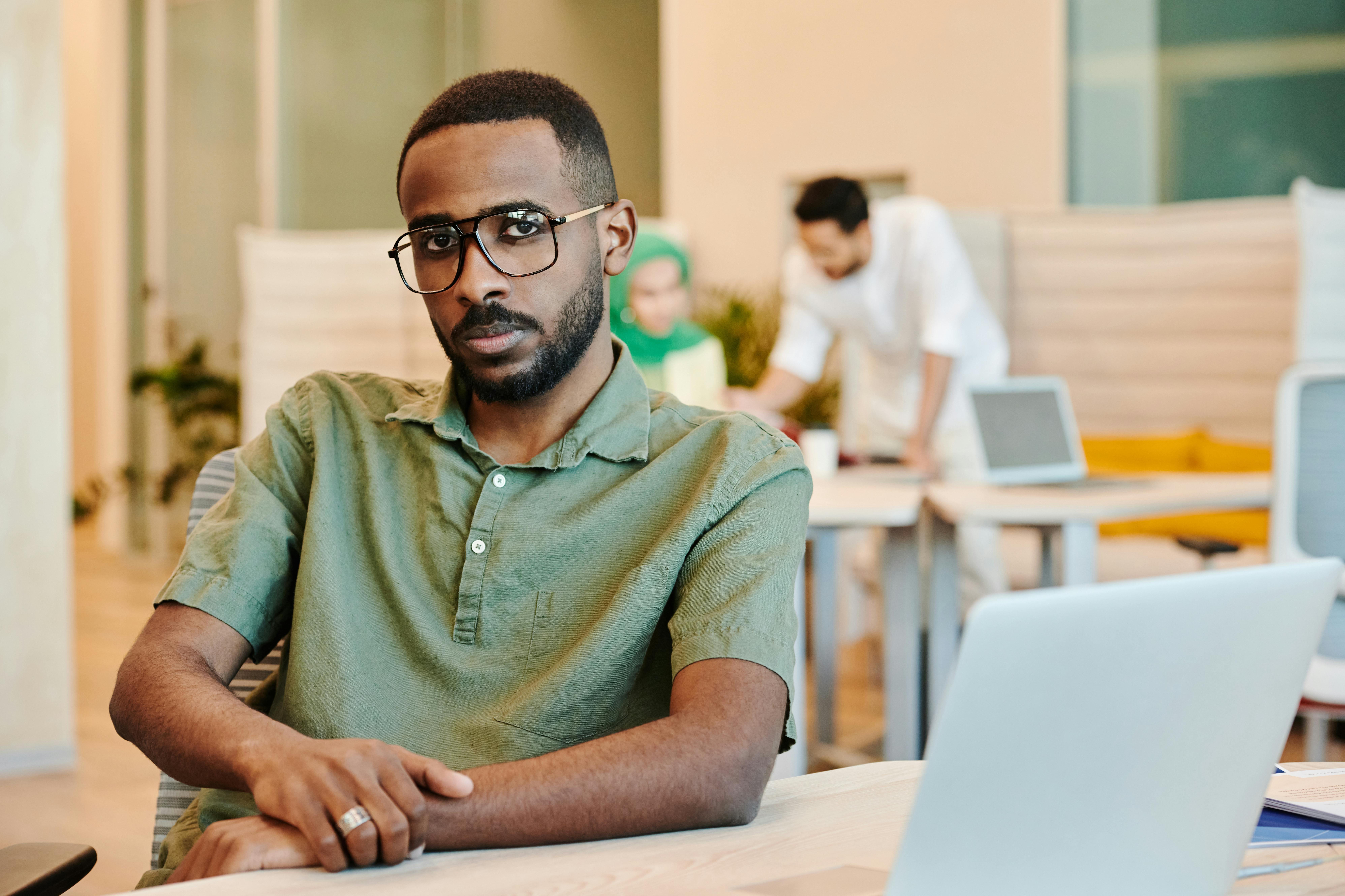Person wearing glasses seated at desk indoors
