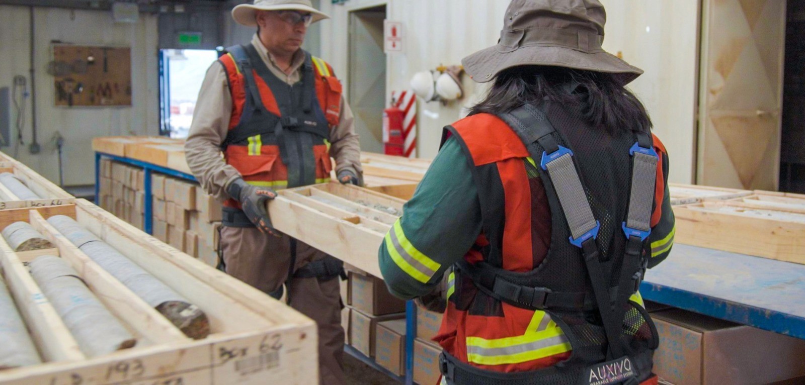 Travailleurs miniers portant l’exosquelette lombaire LiftSuit manipulant de lourdes caisses pour réduire la fatigue et la charge sur le dos