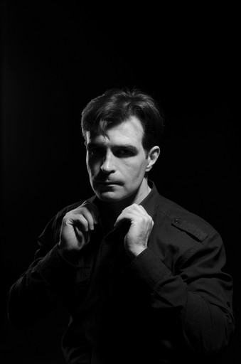 man wearing dress shirt while holding his collar