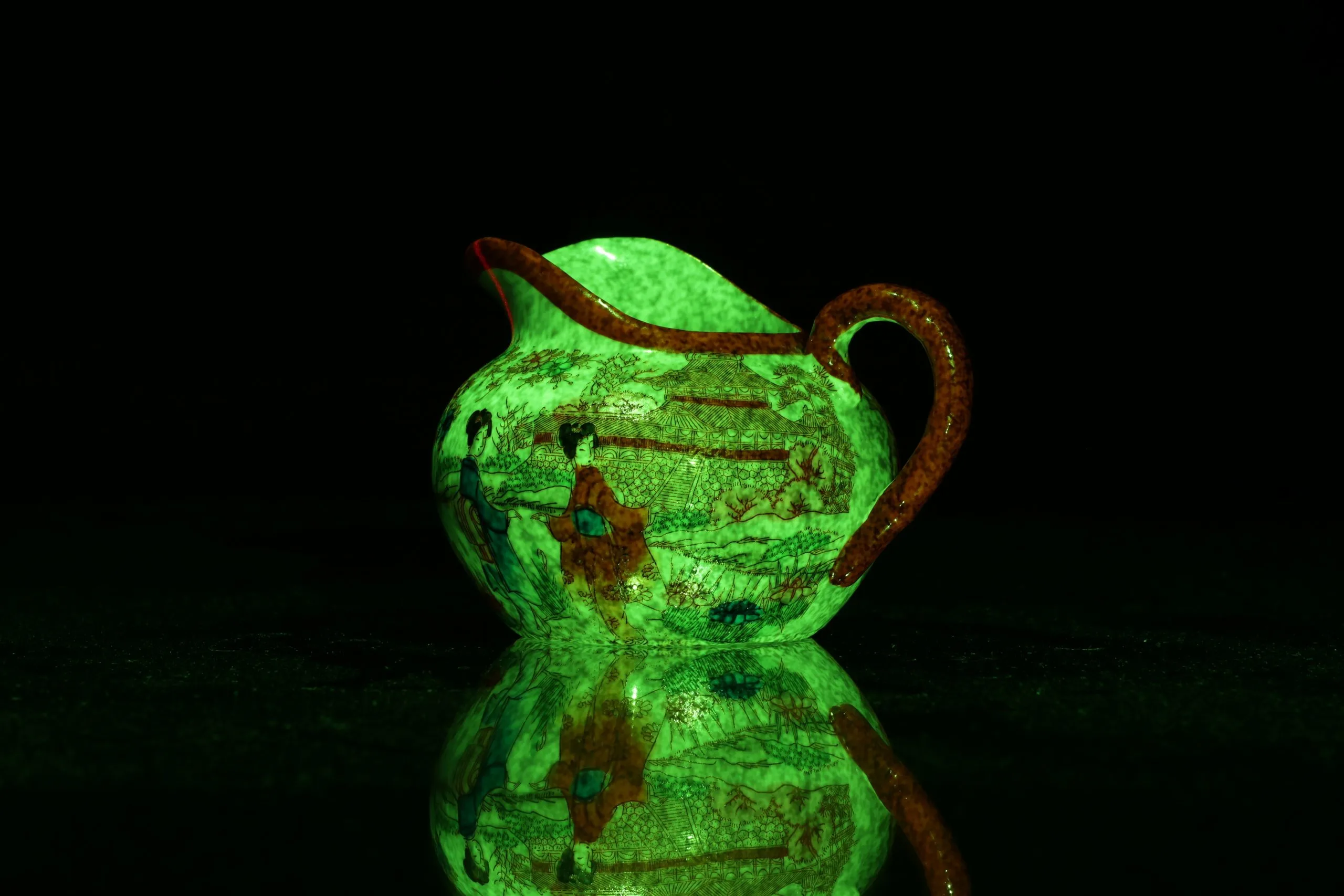Japanese teapot in scanner with green pattern projection projected onto it.