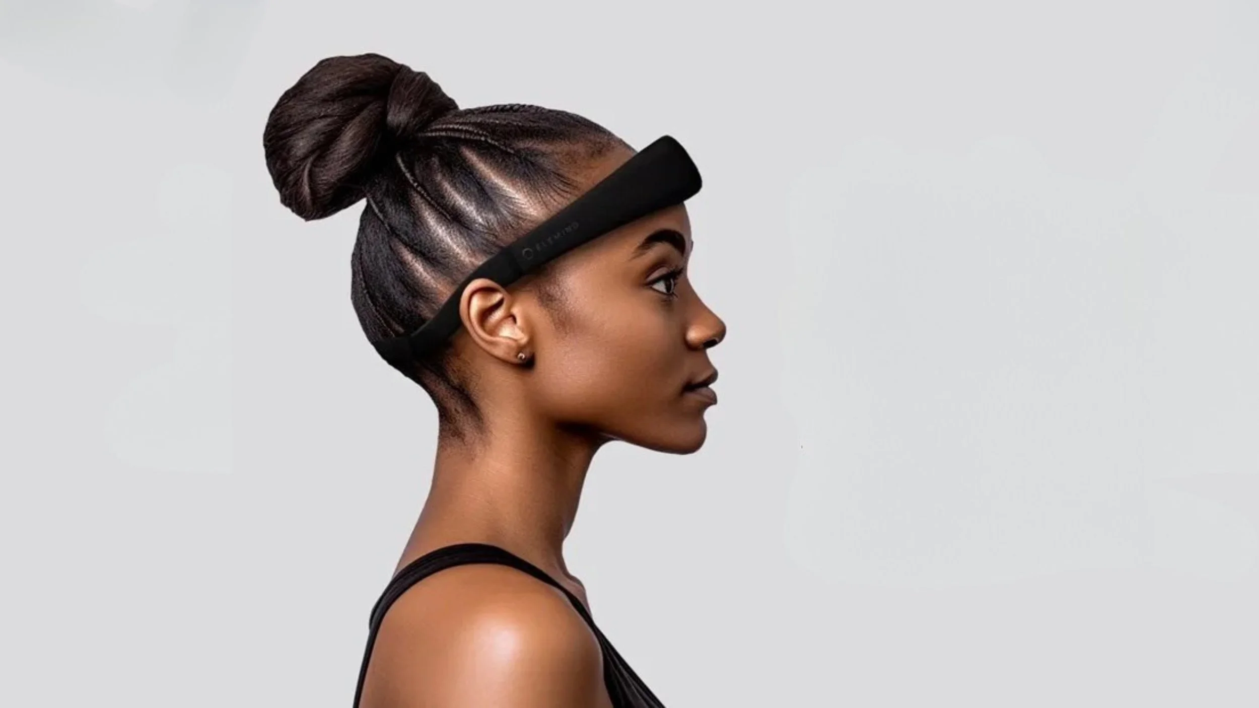 Side profile of a person wearing a sleep headband against a plain background