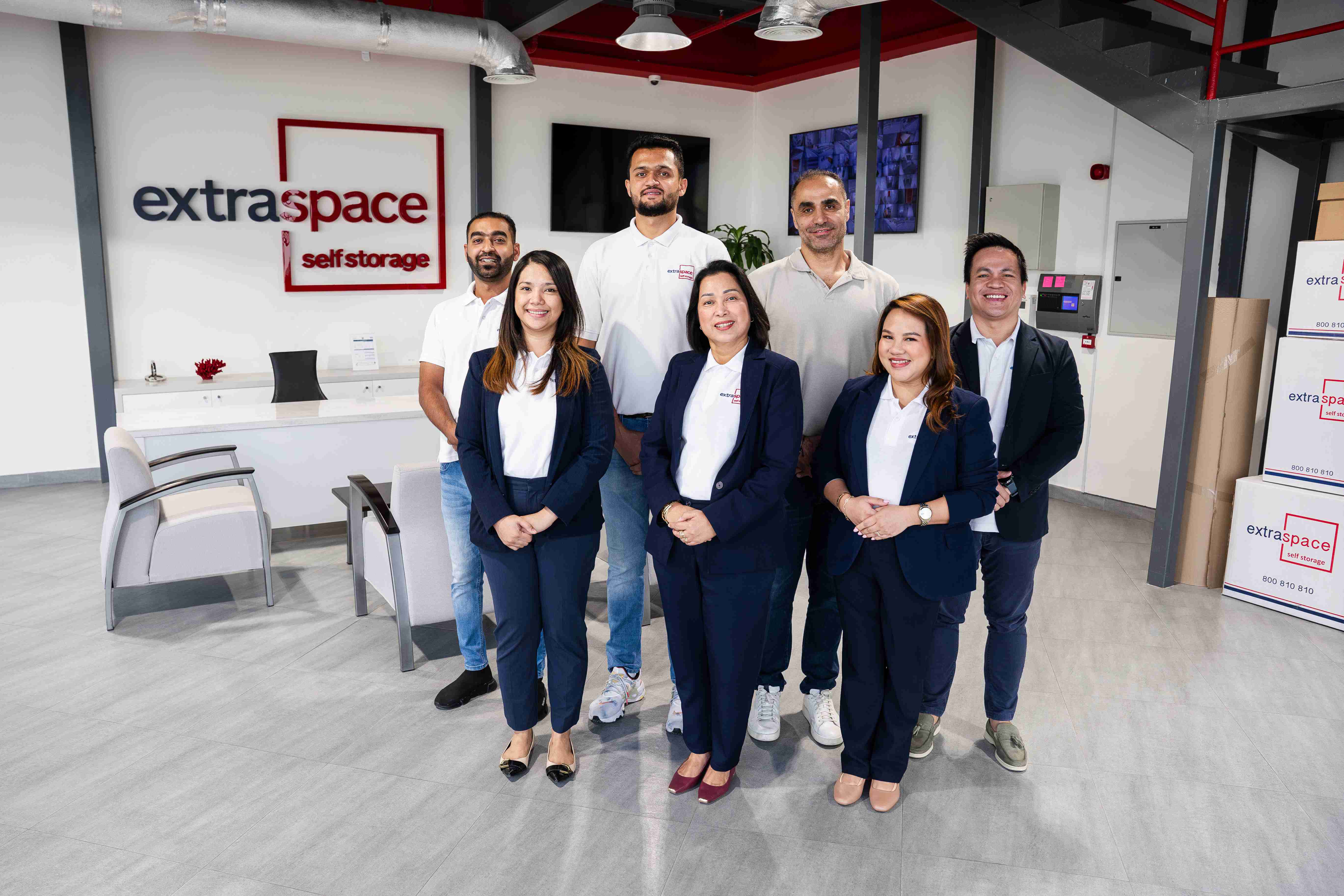 Staff posing in modern office space of Extra Space storage facility Dubai.