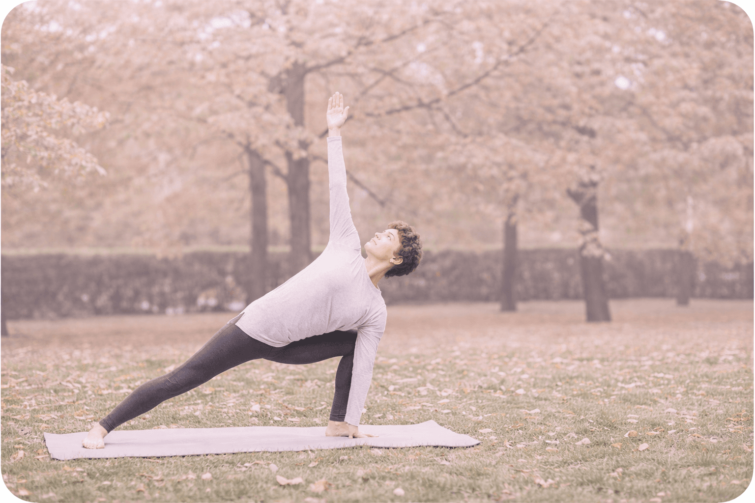 Man practicing yoga on mat in park