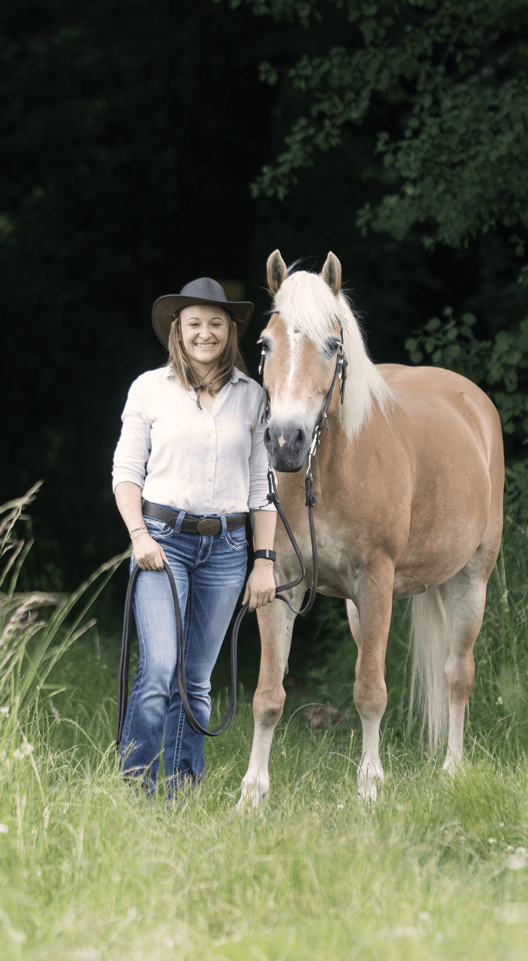 Nicole Rathmayr steht draußen im Wand neben einem Haflinger
